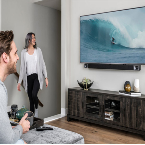 Image homme et femme devant leur télévision avec barre de son